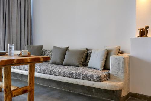 a couch sitting in a living room with a table at Suites of the Gods Cave Spa Hotel in Megalochori
