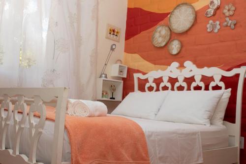 a bedroom with a bed with an orange wall at Chácara Lápis Lazuli in Cavalcante