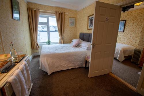 a hotel room with two beds and a window at Ryan's Daughter B&B in Thurles