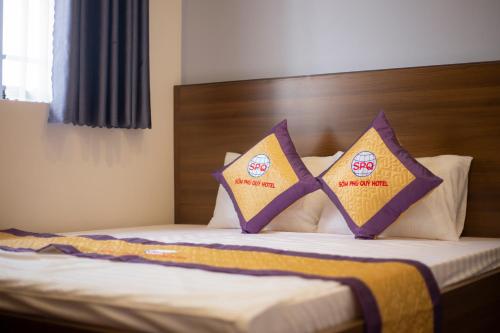 a bed with two pillows on top of it at Khách sạn Sớm Phú Quý - Ninh Thuận in Phan Rang