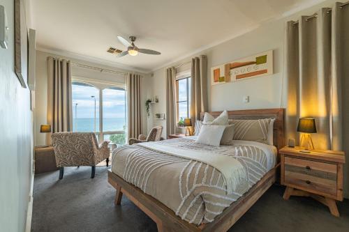 a bedroom with a bed with a view of the ocean at Horizon 235 in Glenelg
