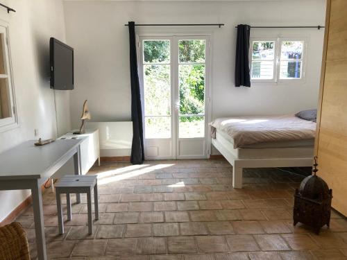Schlafzimmer mit einem Bett, einem Tisch und einem Schreibtisch in der Unterkunft le calme chambre 2 in Saint-Tropez