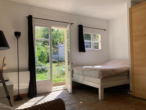 1 dormitorio con 1 cama y puerta corredera de cristal en le calme chambre 2, en Saint-Tropez