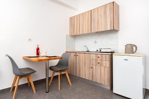 a kitchen with a table and a refrigerator at Marina's Studios in Perivolos