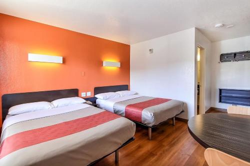 a hotel room with two beds and a table at Park Inn by Radisson, San Jose in San Jose