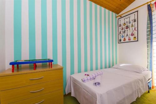 um pequeno quarto com uma cama e uma cómoda em Three bedroom apartment with amazing sea view em Trogir