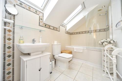 a bathroom with a sink and a toilet and a shower at Coach House Mews in Matlock Bank