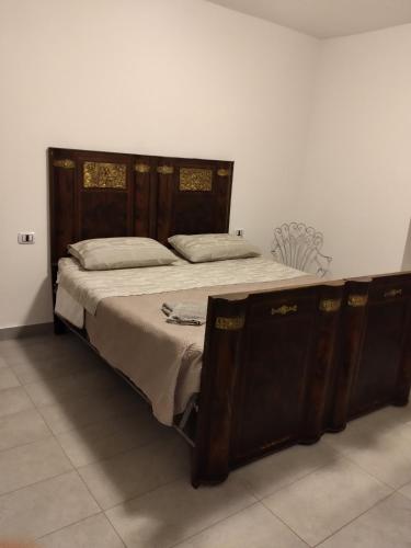 a large bed with a wooden frame in a room at Settesette6 in Barghe