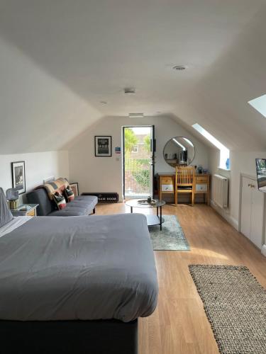 a bedroom with a bed and a living room at The Cherry Tree in Woodbridge