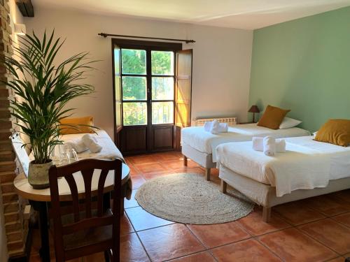 a room with two beds and a table and a table at Casa 'Ohana in Ríoturbo