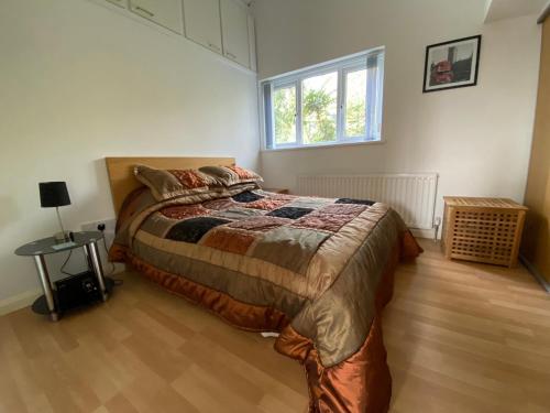 - une chambre avec un grand lit et du parquet dans l'établissement Spacious One Bed Deluxe Apartment in Daventry, à Daventry