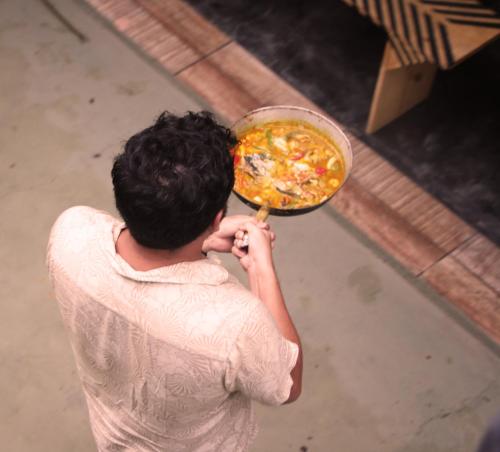 a person holding a plate of food with a pizza at Santo Hostel in Porto Seguro