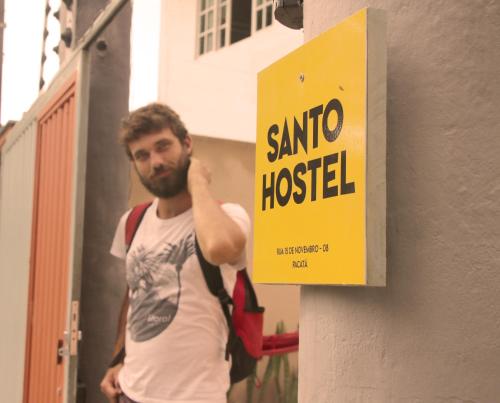 a man standing next to a santa hospital sign at Santo Hostel in Porto Seguro