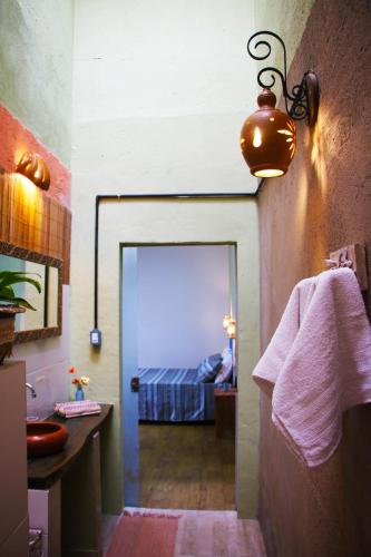 a bathroom with a door leading to a bedroom at Santo Hostel in Porto Seguro