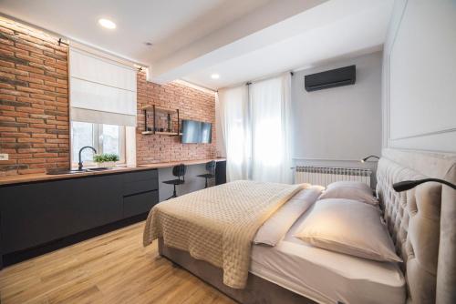 a bedroom with a bed and a sink and a brick wall at Imperial Apartment P, 2nd Floor in Zagreb