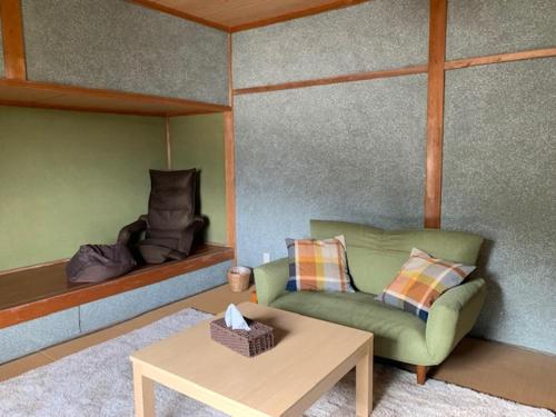 a living room with a couch and a table at Yakuno House in Fukuchiyama