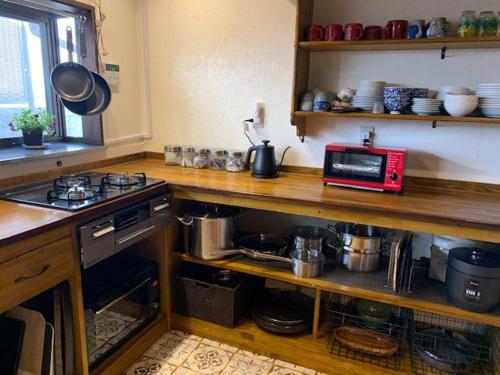 a kitchen with a counter top with a microwave at Yakuno House in Fukuchiyama
