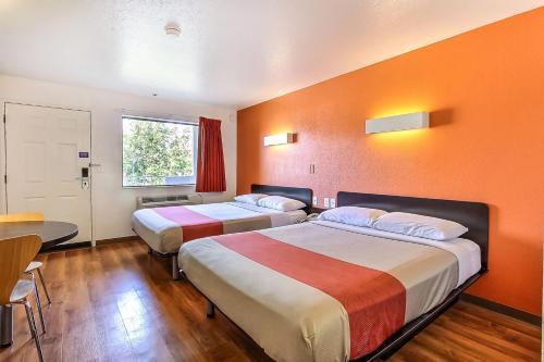 a hotel room with two beds and a table at Motel 6-Sunnyvale, CA - North in Sunnyvale