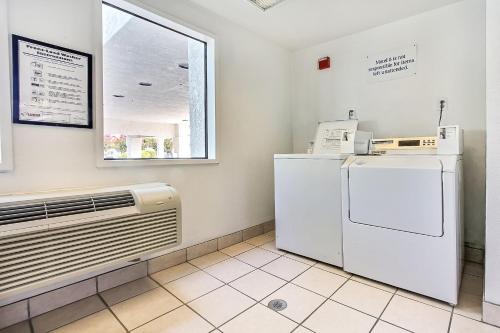 a laundry room with a refrigerator and a window at Motel 6-Sunnyvale, CA - North in Sunnyvale