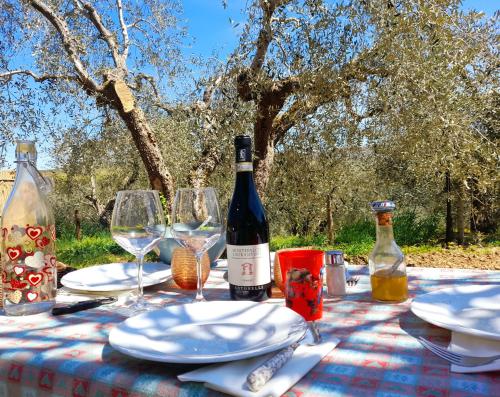 a table with a bottle of wine and glasses at Cottage La Dolce Agogia Panicale in Panicale