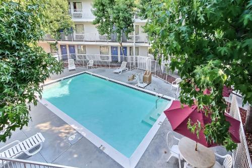 an overhead view of a swimming pool with chairs and an umbrella at Motel 6-Sunnyvale, CA - North in Sunnyvale