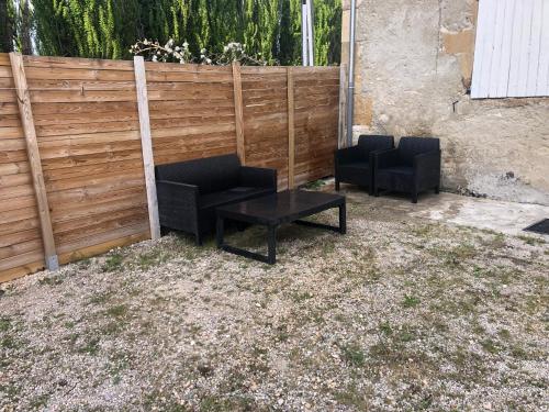 deux chaises noires et une table devant une clôture dans l'établissement Gîte Luna, à Sablet