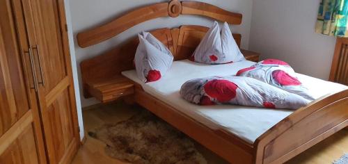 een slaapkamer met een houten bed met kussens erop bij Haus Anicka zum Bömerwaldjeti in Aigen im Mühlkreis