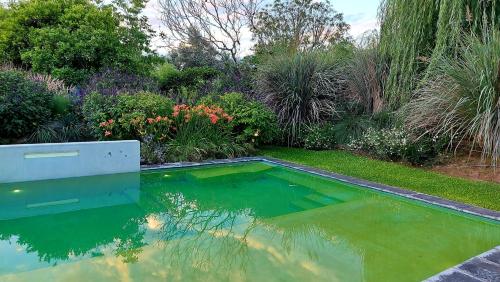 a pool in the middle of a garden at Posada del Santo Green & Rest - Cabañas in Salta