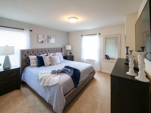 - une chambre avec un grand lit doté d'oreillers bleus et d'une table dans l'établissement Luxury 7BR 6BA Home Private Pool and BBQ only13min to Disney 4788 sqft, à Kissimmee