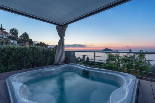 a hot tub on a deck with a view of the ocean at Baba Residences in Alassio