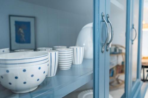 een glazen kast met kommen en borden erop bij Apartment Nobilis in Zambratija