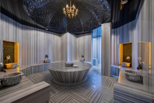 a bathroom with a large tub and a chandelier at Lucky Monkey Hotel in Antalya