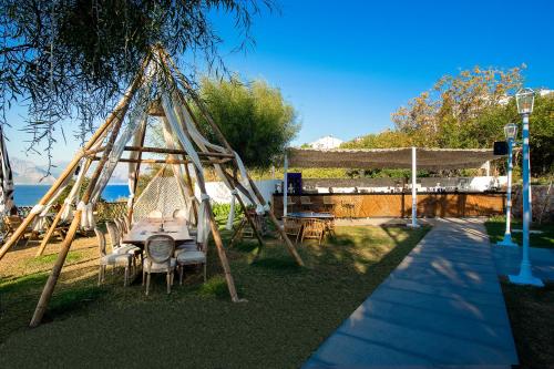 a table and chairs in a gazebo next to the water at Lucky Monkey Hotel in Antalya