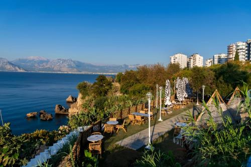 a group of tables and chairs next to the water at Lucky Monkey Hotel in Antalya