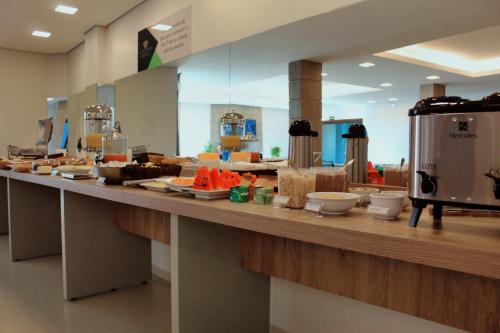 eine Küche mit einer langen Theke mit Essen drauf in der Unterkunft Good Stone Curvelo Hotel in Curvelo