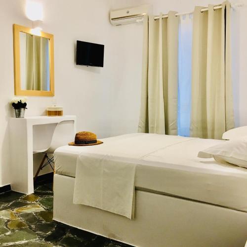 a bedroom with a bed with a table and a television at Nostos Studios in Parikia