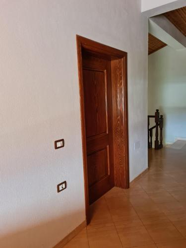 an empty room with a door and a tile floor at Bar Kafe Pjetri Guest House in Patza-Kuqani