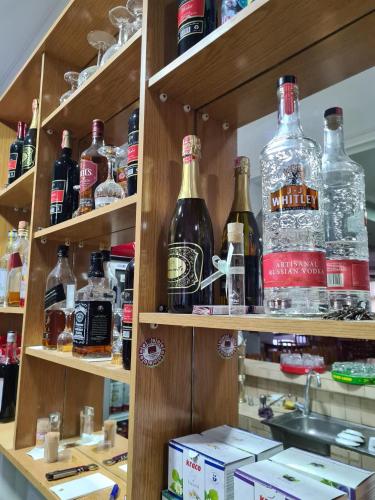 a shelf filled with lots of bottles of alcohol at Bar Kafe Pjetri Guest House in Patza-Kuqani