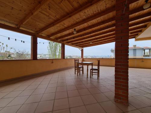 a patio with a table and chairs on a roof at Bar Kafe Pjetri Guest House in Patza-Kuqani