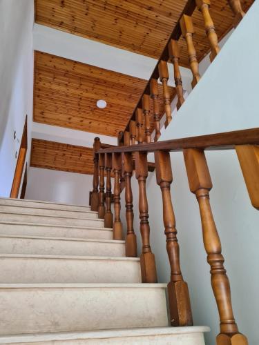 a set of stairs with wooden railings and a wooden ceiling at Bar Kafe Pjetri Guest House in Patza-Kuqani