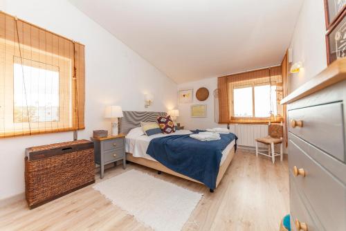 a bedroom with a bed and a desk and two windows at Church Square Apartment in Praia da Luz in Luz