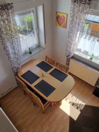 a table and chairs in a room with two windows at Ferienwohnung Eigner in Traben-Trarbach