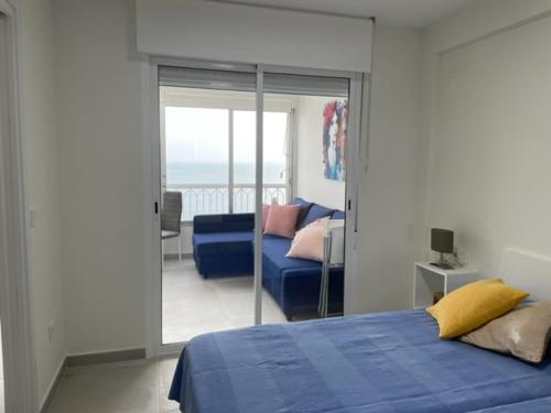 ein Schlafzimmer mit einem blauen Bett und einem Balkon in der Unterkunft Precioso apartamento a estrenar en primera línea de playa in Benidorm