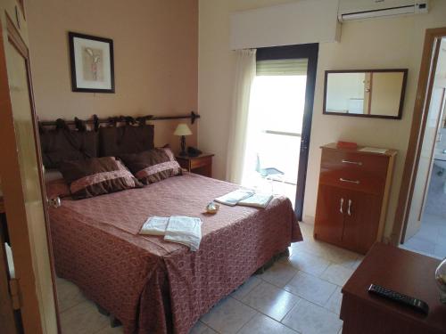 a bedroom with a bed with a red bedspread at Hotel City Piriápolis in Piriápolis