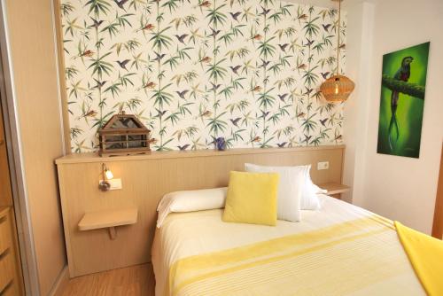 a small bedroom with a bed with a tropical wallpaper at VM Apartamentos Turísticos in Santiago de Compostela