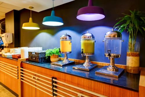 a restaurant counter with three drinks in jars on it at ibis Rio de Janeiro Nova America in Rio de Janeiro