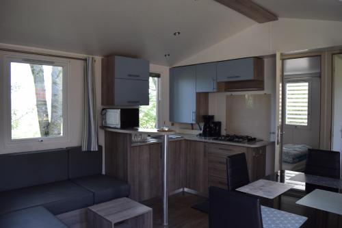 una pequeña cocina con mesa y encimera en Camping La Croix Badeau, en Soulaines-Dhuys