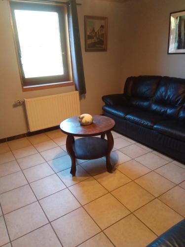 a living room with a table and a couch at Gite à la Ferme in Rouvroy