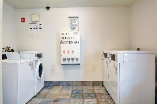 a laundry room with washing machines and a sign on the wall at Motel 6-Wethersfield, CT - Hartford in Wethersfield