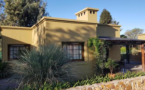 a yellow house with a fence in front of it at Posada del Santo Green & Rest - Cabañas in Salta